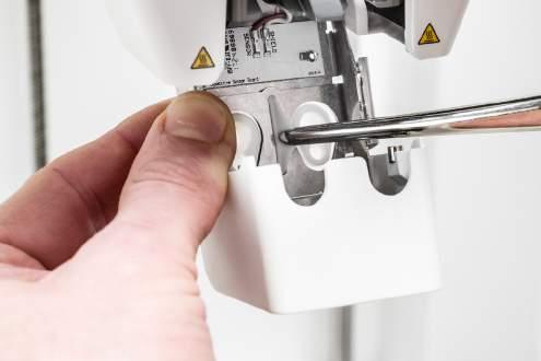 Työnnä etukaistale tulostuspään tuulettimen kannattimen aukon läpi samalla kun kohdistat painetta metallilevyyn tulostimen sisältä.