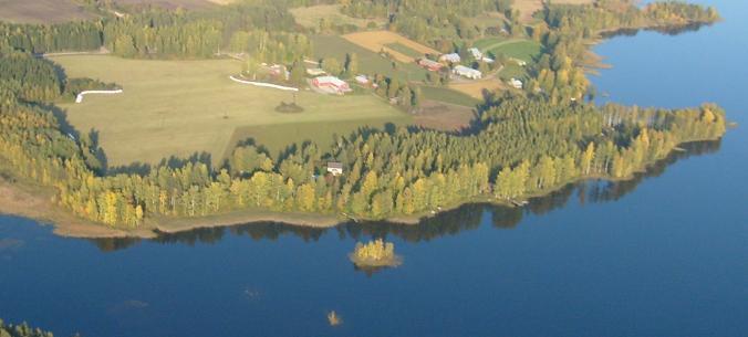 Kuva 5-58 Näkymä yli Rötsönlahden kohti Paljakan kylän Kupialaa vuosina 1990 (ylempi kuva) ja 2008 (alempi kuva). Kuvien Heimo Paakkinen.