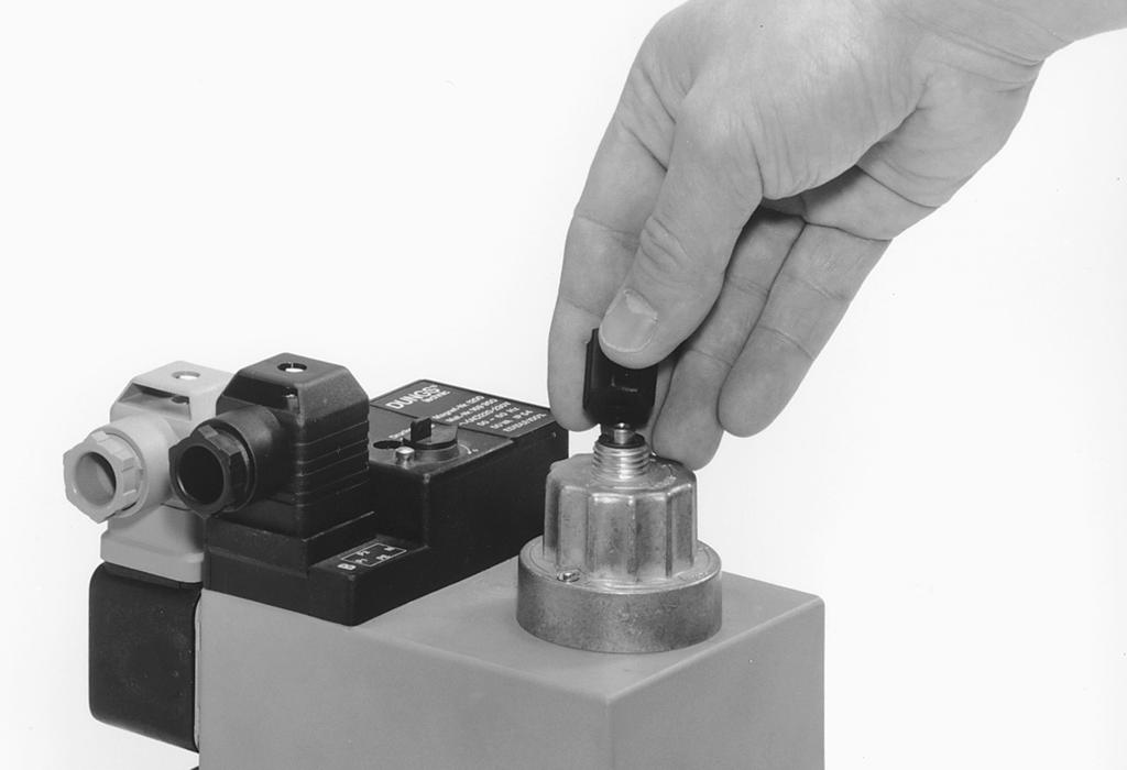 . Vend indstillingskappen og benyt den som værktøj.. Drejning med uret = forøgelse af hurtigslaget (+).. Skruva bort inställningslocket E från hydrauliken.