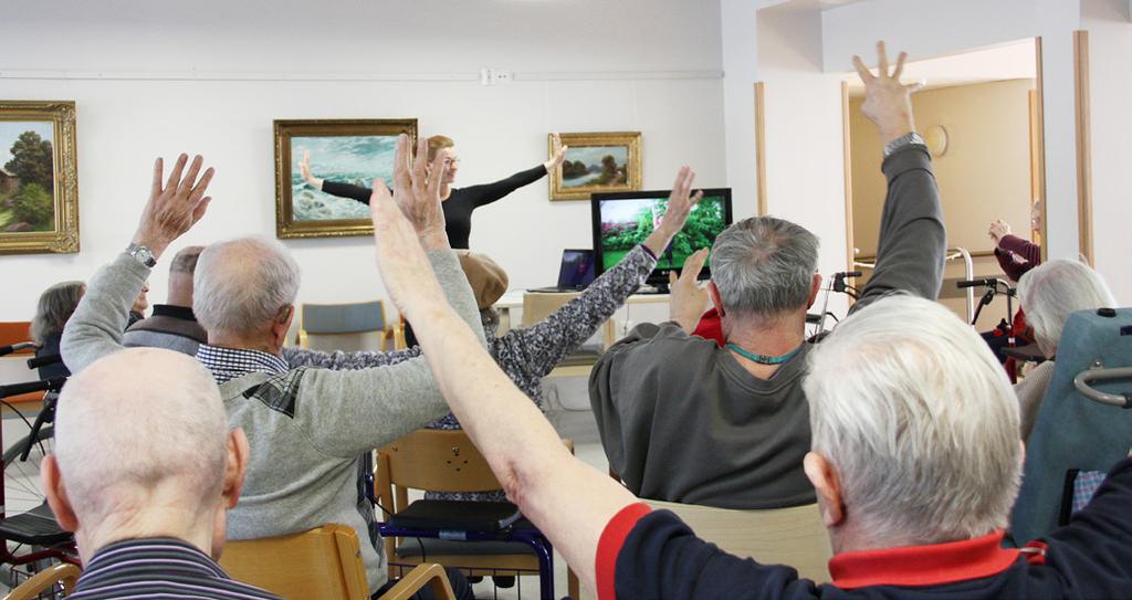 Kuva 6. Hyvinvointiteknologiapalveluiden koettiin motivoivan asiakkaita liikkumaan. Kuvassa Porin suomalaisen palvelukodin asiakkaat treenaavat Seniors-palvelun harjoitteita.