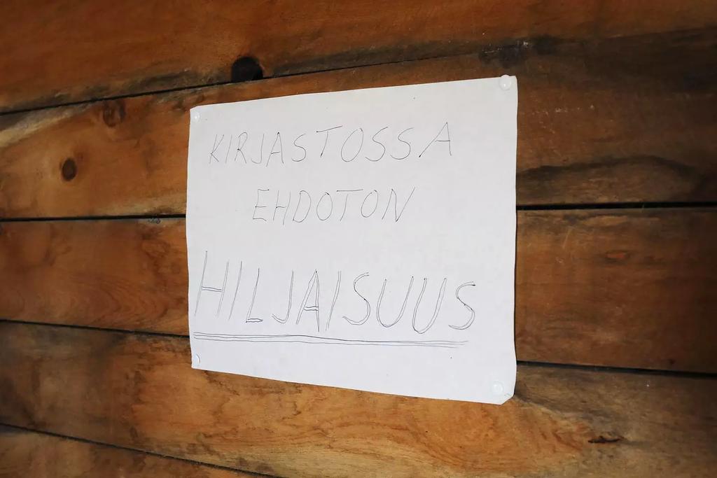 Kullankaivajien huumori kukkii seinälapussa. (KUVA: JUKKA GRÖNDAHL / HS) Riskejä syrjäisessä kirjastossa asiointiin kuitenkin liittyy.
