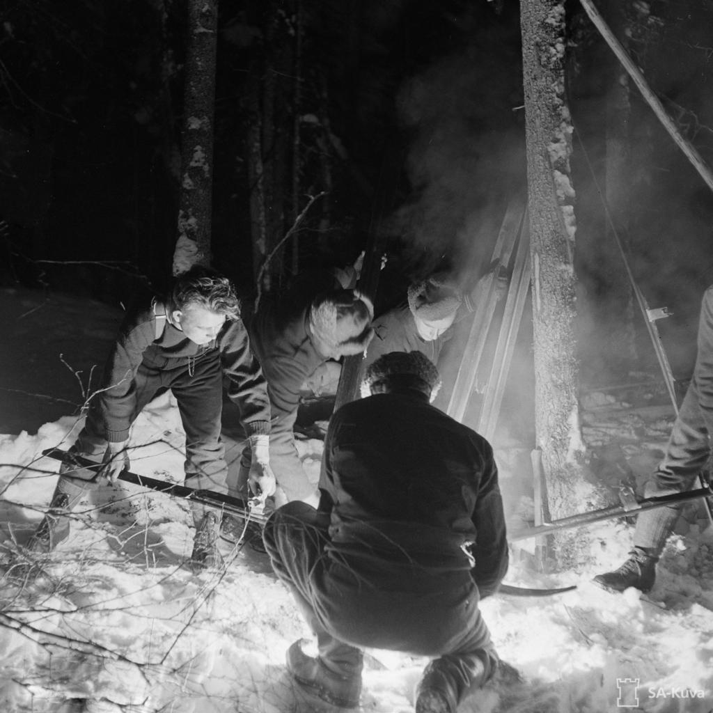 Suksia paahdetaan ampumahiihtokilpailua varten vuonna 1942. Terva ja savu tuoksuivat, kun puusuksia voideltiin tervalla nuotion ääressä kesken matkantekoa.