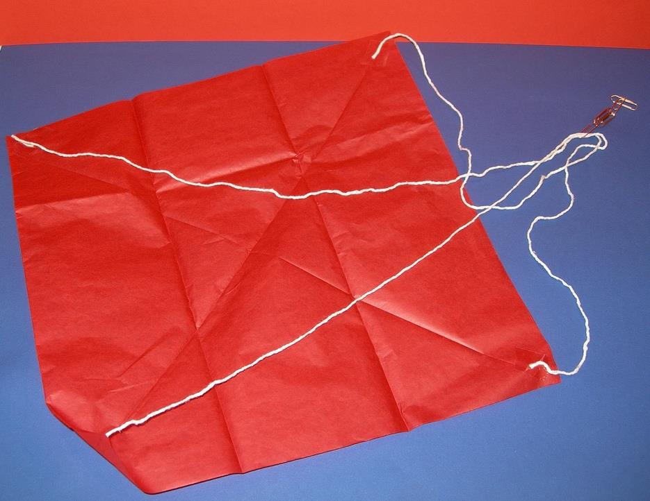 Oppilaan ohje: Laskuvarjo - silkkipaperia - ohutta narua tai lankaa - sakset - klemmareita - teippiä Miten tehdään: 1. Leikkaa silkkipaperista neliskulmainen pala. 2.