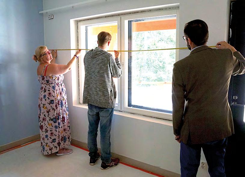 Päivi, Joonas ja Kare Norvapalo mittaavat Joonaksen asunnon