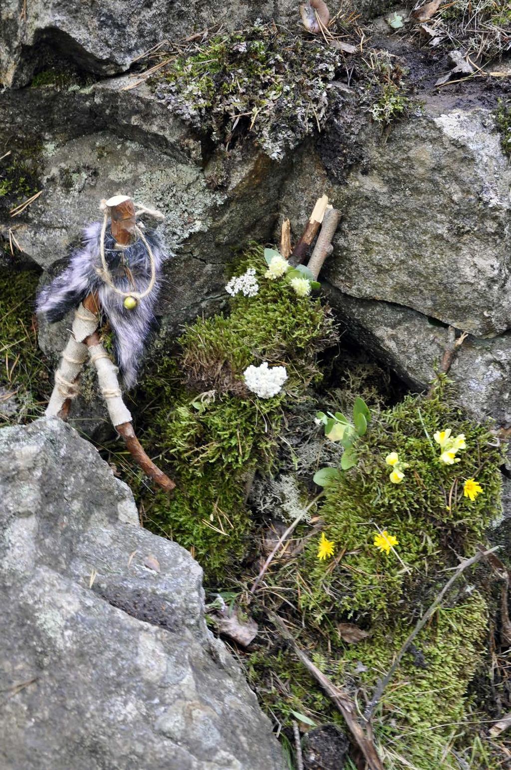 Kallion ja mättäiden väliin on syntynyt pieni, oksilla ja lehdillä katettu maja, josta lähtee polkuja ympäristöön.