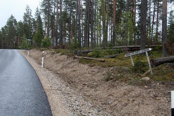 Tien vastakkaisella puolella on kaatumaisillaan oleva Karjalan Kierros -viitta,