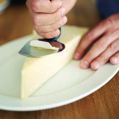 Pystykahvan alaosa on taivutettu, jotta käsi ei kosketa juustoa. "Aaltoileva" terä nostaa juusto- tai vihannesviipaleen irti terästä.