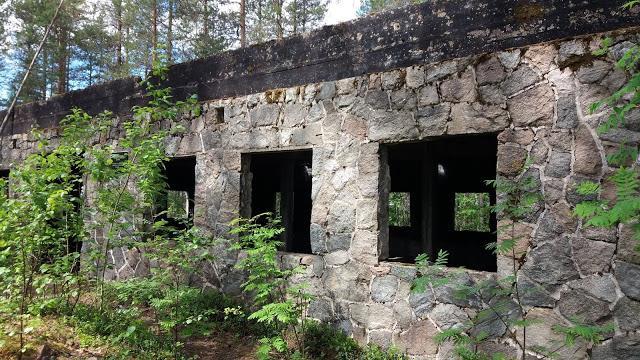 Yläreunan mustan pikimassalla voidellun osa päälle oli leikattu puolikkaat hirret, aina rapatun kiviosan yläreunaan saakka.