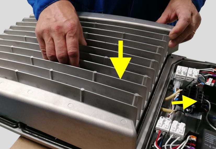 5. Aseta uusi valoyksikkö valaisimen päälle siten, että voit ohjata LED-Moduulien liitosjohdot johtokäytävästä valaisimen