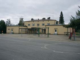 1932, Iisalmen uimarannan rantapaviljonki v. 1934). Rakennuksen muodostaa kaksikerroksinen päämassa ja sitä pihanpuolelta rajaavat symmetrisesti siipiosat.