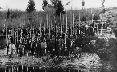 KEIJO JAAKOLAN KOK. TUKKIEN UITTAMINEN SAHOILLE JA LASTAUSPAIKOILLE TYÖLLISTI SUUREN MIESJOUKON. UITTOMIEHIÄ KEKSEINEEN JOKIMÄENKYLÄSSÄ 1920-LUVULLA. työmiehille 1 kannu.