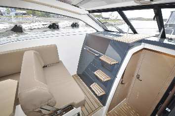 Molemmista päistään mukautuvalla sohvaryhmällä on juhlavasti mittaa ja se muodostaakin veneen sosiaalisen keskuksen. Pöytään herkkua HT-katolla varustetuissa cruisereissa.