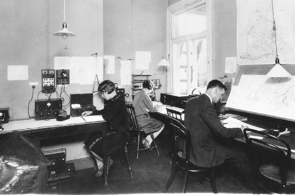 Meteorologisen keskuslaitoksen sääosaston johtaja Kuva 31. Näkymä Meteorologisen keskuslaitoksen sääpäivystykseen Kaisaniemessä lokakuussa 1931. Oikealla Jaakko Keränen sääkarttojen äärellä.
