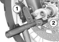 z Huolto Aseta moottoripyörä ennen nostamista BMW Motorrad etupyörän huoltopukille aputelineen varaan. Nosta moottoripyörä tarkoitukseen sopivan aputelineen varaan.