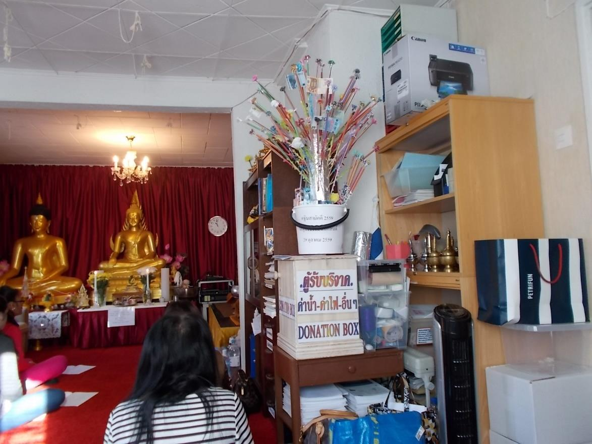 Taustalla Buddhan kuvat.