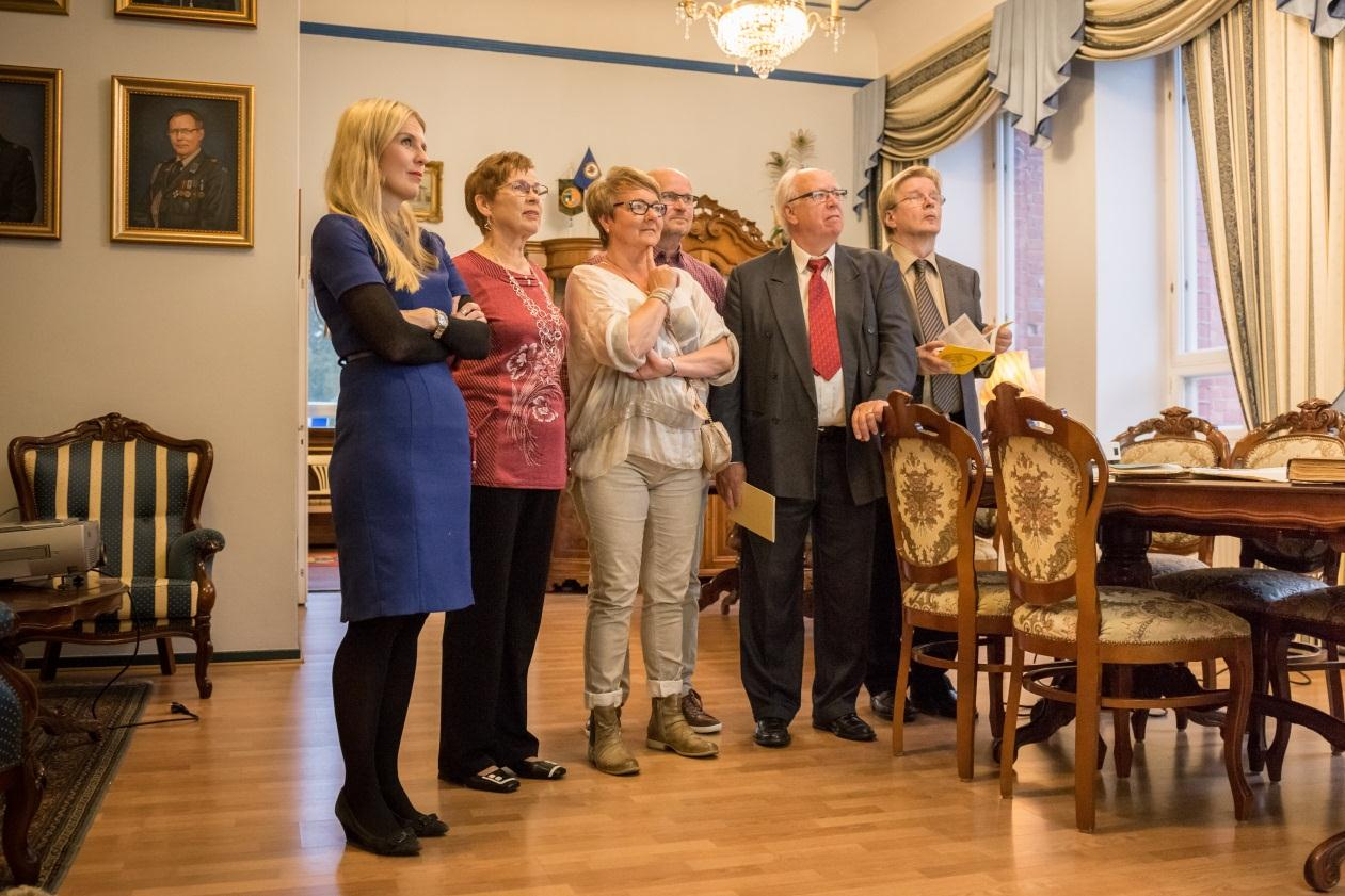 Juhlavieraita katselemassa menneiden vuosien kuvakoostetta.