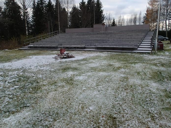 Tekstissä mainittu rakennuksen peruskivi on vasemmalla näkyvällä joutomaalla, rinteessä. Idästä.