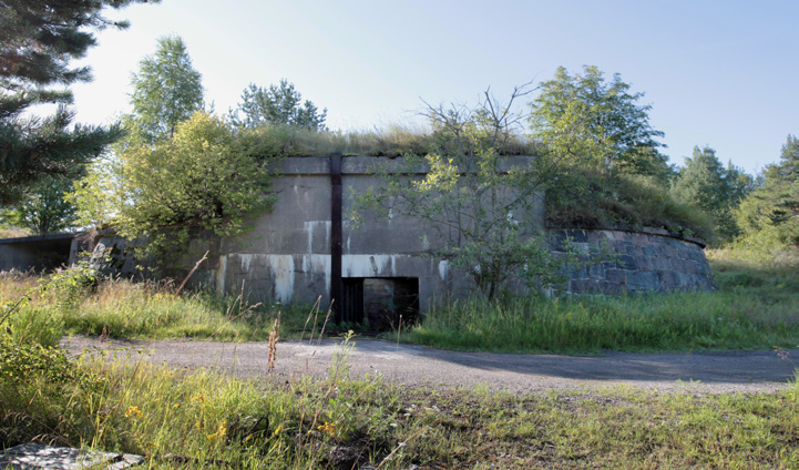 Rakennuksen itäpuolella on jäänteitä puretun kasematin kivisestä tukimuurista sekä osittain maan sisälle louhittu betoninen miinaverkon akun kasematti (V10), jonka pohjoisjulkisivuun on