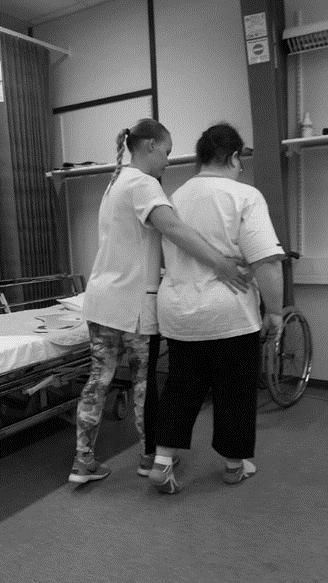42 Jos hoitaja tukee potilaan kävelyä sivulta (kuvio 20), tulee hänen olla hieman potilaan takana ja tukea potilasta toisella kädellä lantiosta ja toisella kädellä potilaan kädestä.