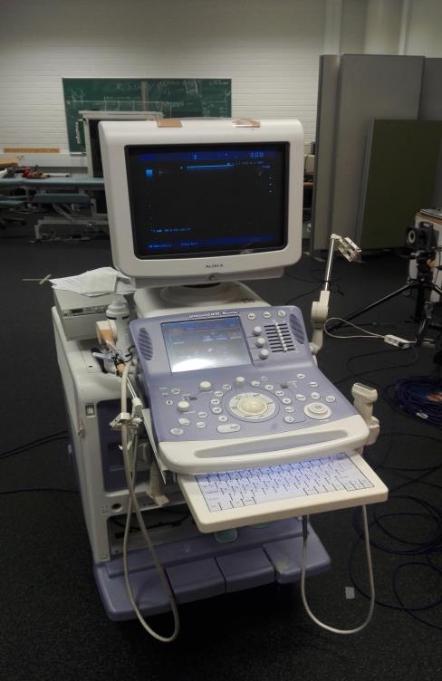 KUVA 1. Aloka Alpha 10 ultraäänilaite. Oikealla näkyy tutkimuksessa käytetty äänipää. Sama mittaaja toimi jokaisella mittauskerralla ultraäänilaitteen käyttäjänä.