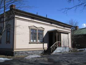 Bomanin vuonna 1879 Suomen tarkk ampujapataljoonia varten laatimia tyyppipiirustuksia Rakennuksen kivijalka on harmaakivestä ja runko veistetyistä hirsistä, julkisivuissa on vaakalaudoitus.
