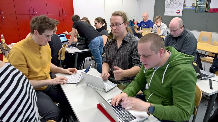 Kurssilaisia materiaalia työstämässä. ryhmä syventävää harjoitteluaan suorittavia fysiikan aineenopettajaopiskelijoita.