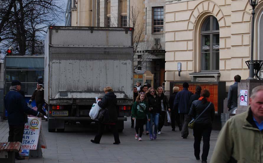 Ajoradalla mahtuu kohtamaan kaksi kuvassa näkyvän kokoista kuorma-autoa. Jalkakäytävillä seisovat autot eivät ainoastaan vaikeuta ihmisten liikkumista.