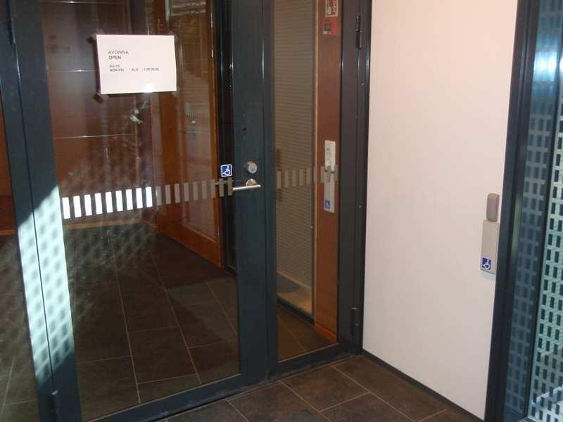 Oven avauspainike on sijoitettu ahtaaseen paikkaan. Opasteet Oviopasteiden tekstit ovat sijoitettu suoraan ovien lasipinnalle.