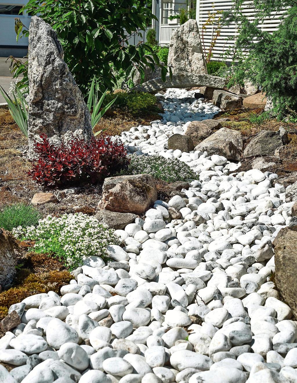 Japanilaista puutarhaa hallitsee järvialue, jolle laskee joki.