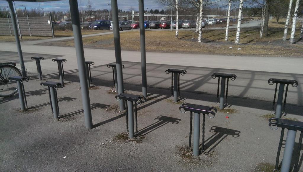 Kuva 17 Hyväkuntoiset tolppatelineet mahdollistavat erikokoisten polkupyörien pysäköinnin radan itäpuolella (Kuva Henri Luoto 2016).