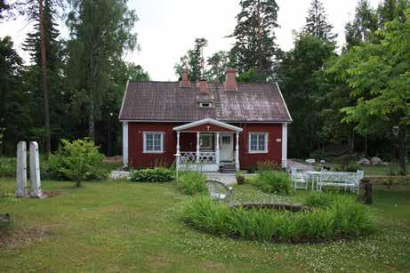leveät nurkkalaudat, parittaiset kuusiruutuiset ikkunat sekä profiloiduin pylväin ja ristikkokaitein koristeltu avokuisti.