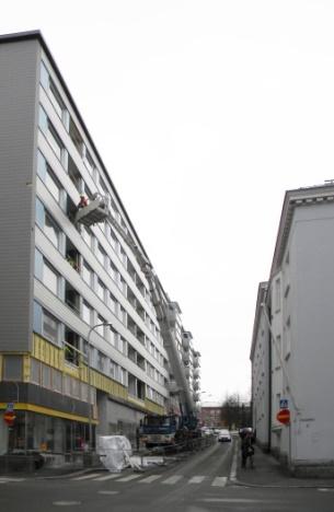 Katutilaa rytmittävät modernististen lamellikerrostalojen päädyt ja matalammat liiketilat.