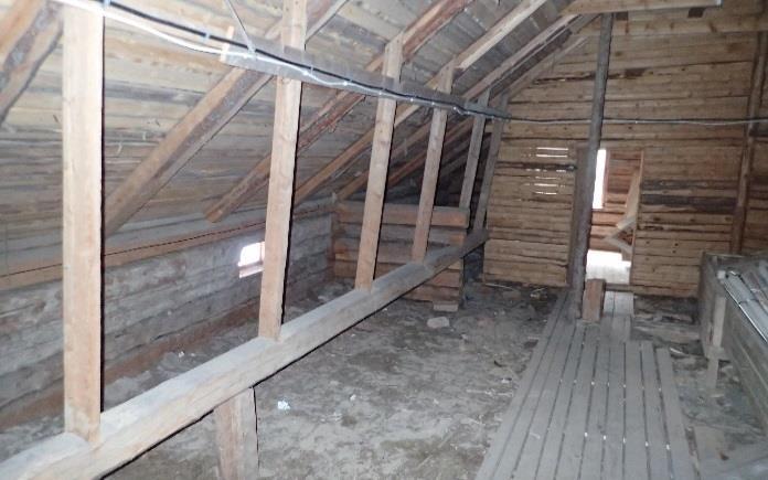 Lattian betonilaatta on valettu hirsirunkoa vasten. Lattian höyrynsulkumuovi on nostettu hirttä vasten.