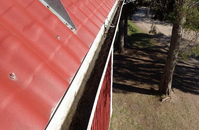Kuva 118. Räystäskouruissa havaittiin roskaa. Lumiesteet on kiinnitetty peltikatteen läpi. Tiivisteitä ei kiinnityskohdissa havaittu.