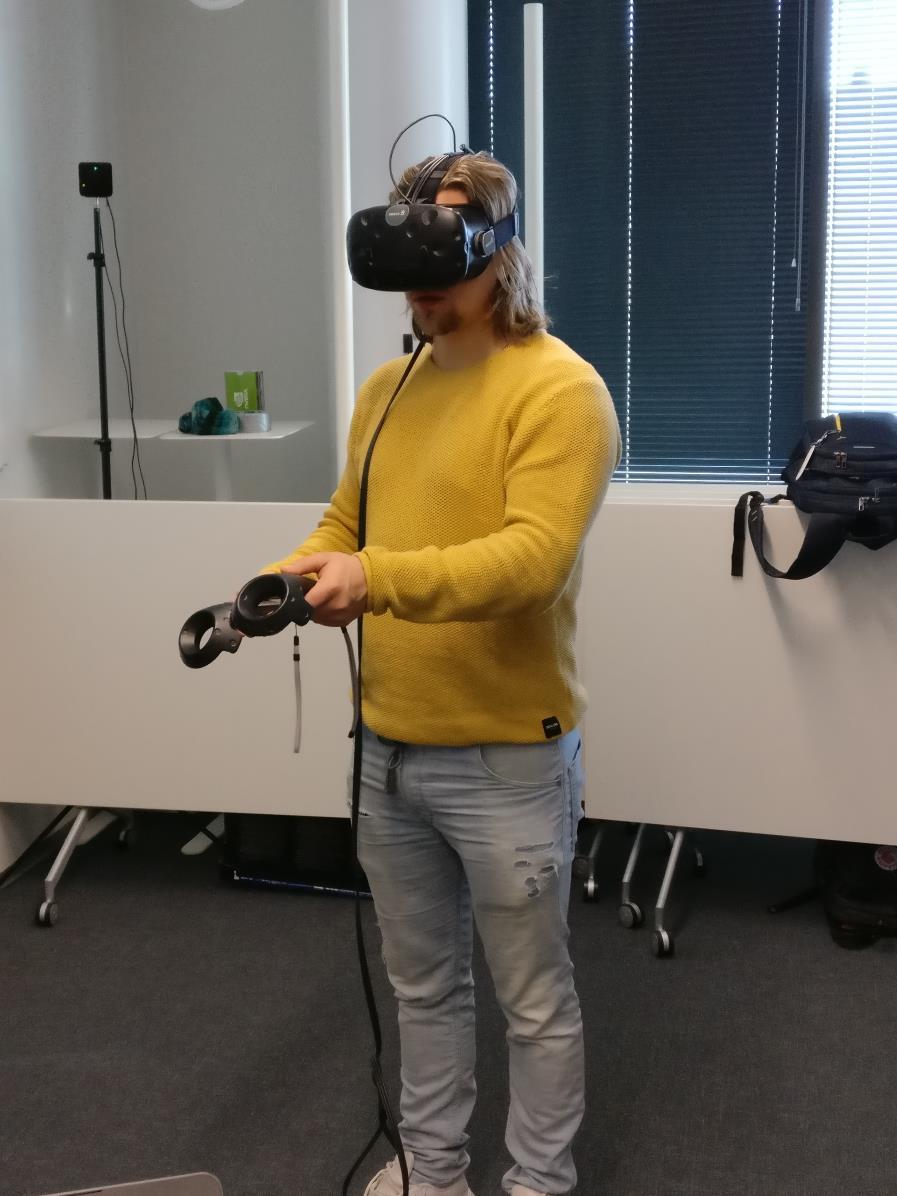 31 KUVA 14. Tietokonekäyttöisten HTC Vive VR-lasien käyttöä liikeohjaimien kanssa. 5.2.