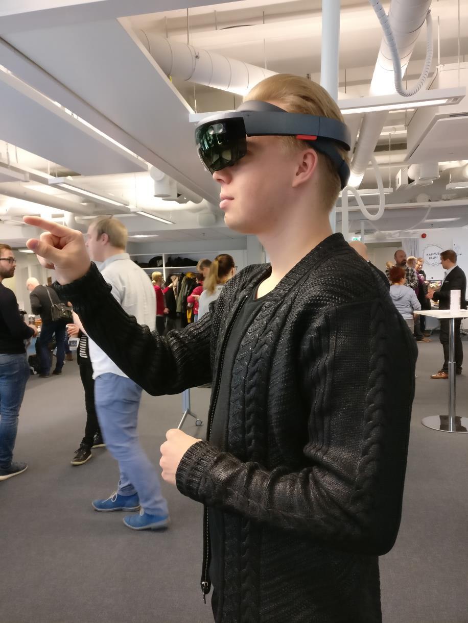 32 KUVA 15. Microsoft Hololens AR-lasien käyttöä. AR-lasien toimintaperiaate perustuu läpinäkyviin linsseihin, joiden väliin on sijoitettu kaksi pikaprojektoria.