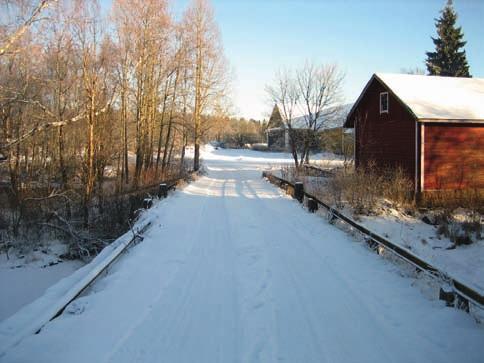 Silta, oikealla vilja-aitta, vasemmalla myllyn