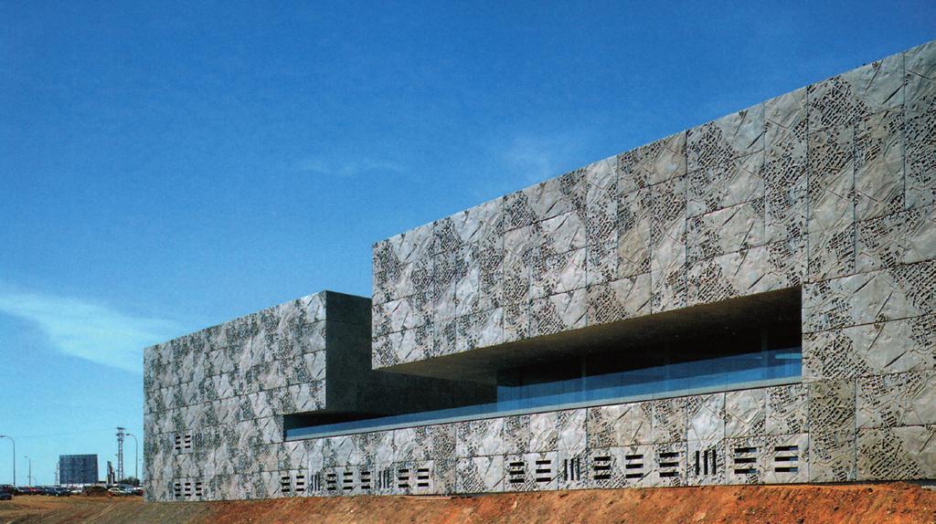 Mèridan järeä kulttuurikeskus 11 Kongressikeskuksen jyhkeä betoninen julkisivu avautuu Guadiana-joelle. 12 Kumimuotteihin valetuissa elementeissä on kuvattu reliefimäisesti asemakaavoja.