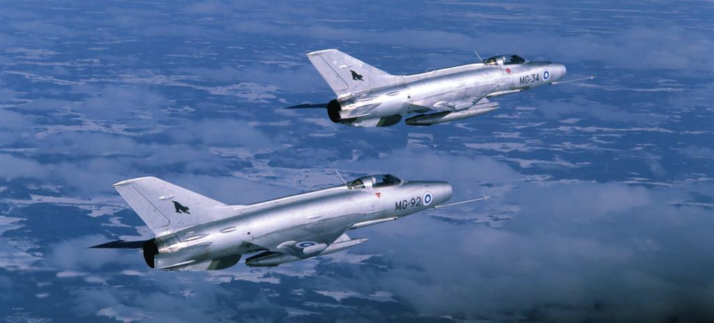 HävLLv 31:n MiG-21F-13-hävittäjät MG-92 ja MG-34 lennolla talvisella taivaalla. MiG-21F-13:t muodostivat laivueen hävittäjäkaluston 1970-luvulla.