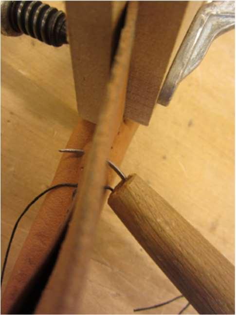 Pujota lanka ensimmäisestä reiästä neulalla ja kiristä langan keskikohta tupen ylälaitaan. Pujota toisella neulalla vastakkaisella puolella samasta reiästä.