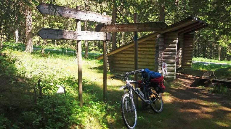 kohdalla polulle, joka johtaa sakeassa kuusikossa