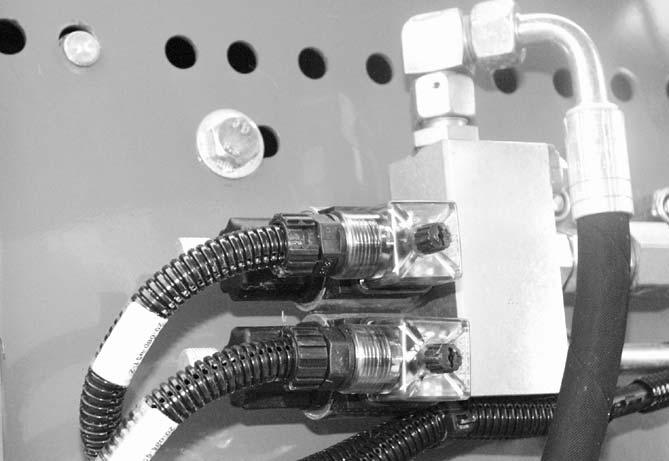 Huolto 9.6.3 Sähkömagneettinen venttiili Sähkömagneettiset venttiilit () sijaitsevat koneen vasemmalla puolella suojuksen takana.