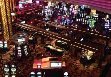 KUVA 3. Osa Planet Hollywood kasinon pelialueesta Las Vegasissa. Pöytäpelit on aseteltu ryhmiin, ja niitä ympäröi satojen peliautomaattien näennäisen sekalaiset ja sattumanvaraiset rivistöt.
