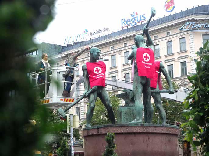 MARI VEHKALAHTI Helsingissä Kolme Sepän patsas puettiin punaisiin kerääjäliiveihin Nälkäpäivän kunniaksi.