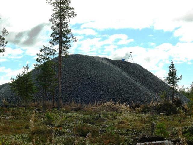 Kuva 3. Syysmuuton tarkkailuun käytetty kivimurskekasa Pyhäjoen Mäkikankaan alueella. Kasan laella näkyy pystytetty kaukoputki jalustoineen ja sininen retkituoli. Valokuva Marko Vauhkonen. Taulukko 1.