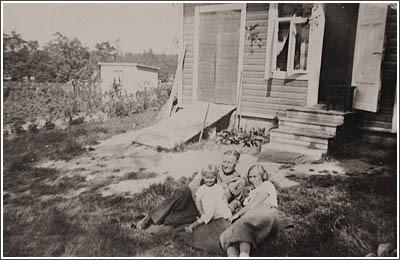 Tammelundin tontille nousi ensin mökki. Tämän kuvan aikoihin, noin vuonna 1937, saattoi talokin olla jo valmis. Ukki ja mummi loikoilevat Jennyn tytär Säteen kanssa pihalle levitetyllä viltillä.
