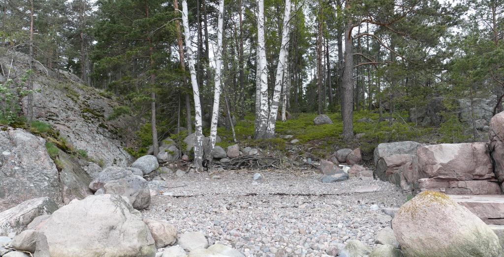8 Yllä saaren itärannalla oleva poukama. Oikealla puolella olevat kalliot ovat lohjenneet tasaisiksi pöydiksi. Vasemmalla saaren eteläkärjessä olleen keittopaikan jäännöksiä. 3.