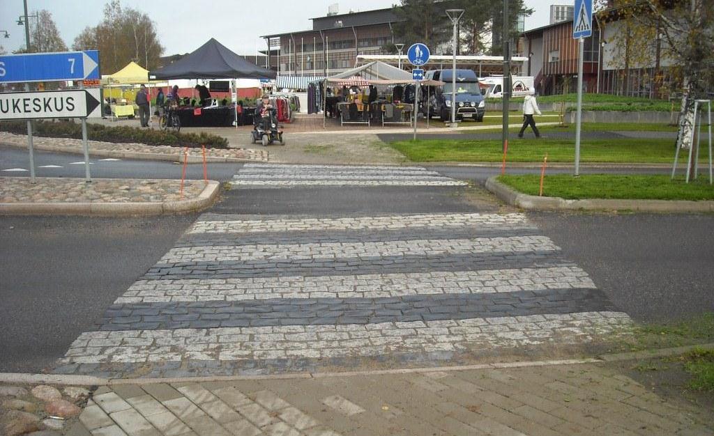 KUVA 23. S-marketin ja K-marketin välinen uusi yhteys Suojateitä käyttävät jalankulkijat pääsivät sujuvasti ylittämään tien autoilijoiden väistäessä heitä.