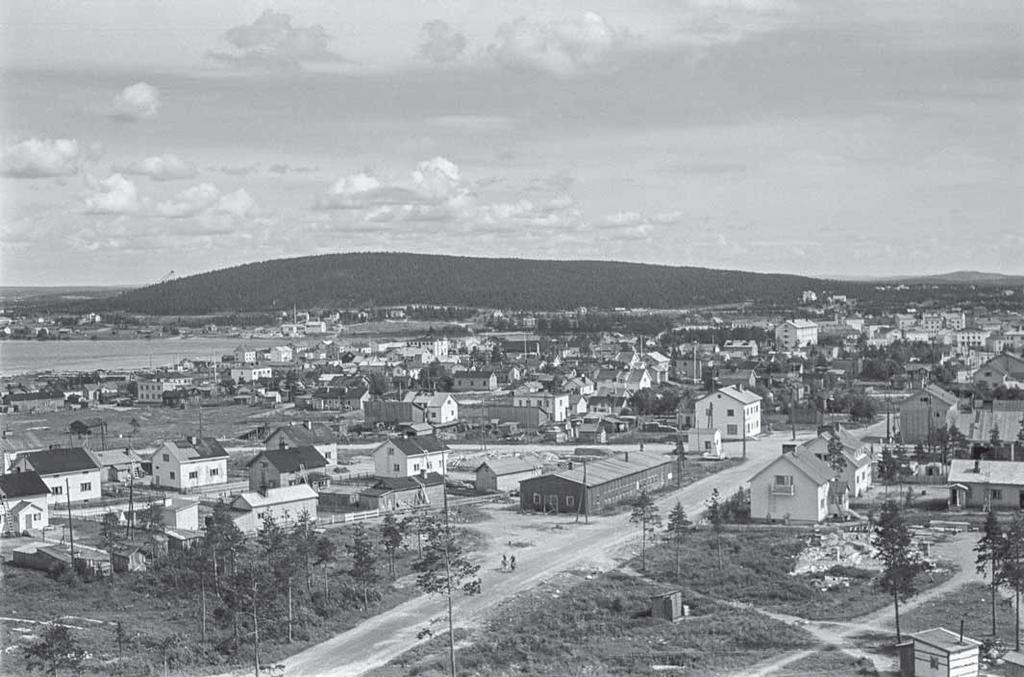 Keskellä kuvaa Koskikadun loppupäässä oli iso OT:n autokorjaamoparakki, joka säilyi tuholta. Kuva on vuodelta 1952. Kuva: Lapin maakuntamuseo.