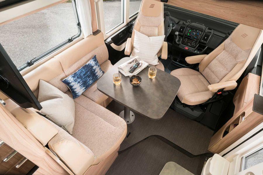 Joustava pöytä Hymermobil Exsis-i -mallin oleskelutilan pöytää tässä kalustesävy Chiavenna Nussbaum